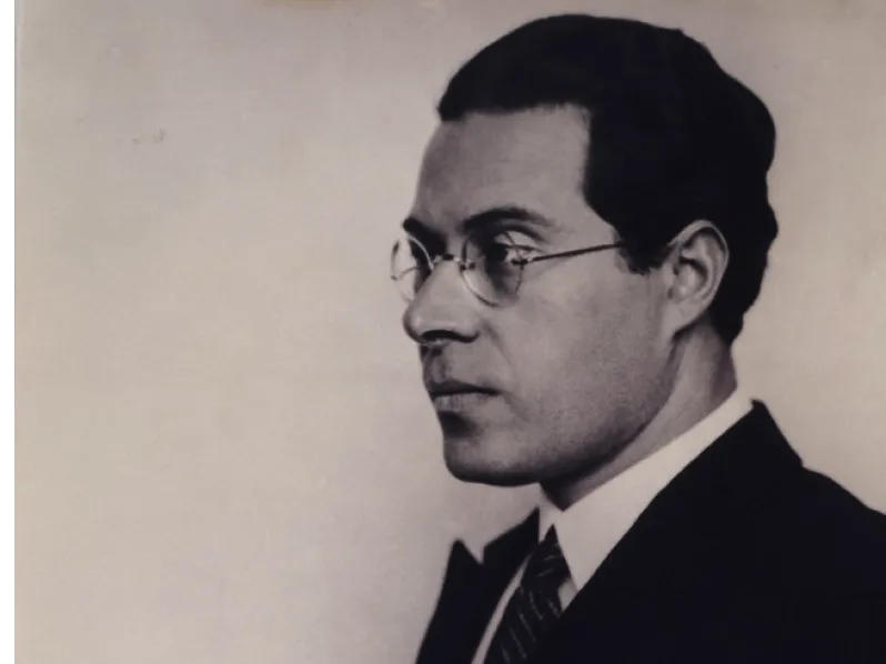 Portrait en noir et blanc de László Moholy-Nagy, vu de profil, portant des lunettes